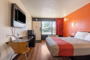 a hotel room with a bed and a desk and a television at Motel 6-Little Rock, AR - West in Little Rock