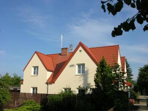 a white house with a red roof at Willa Katrin in Mikołajki