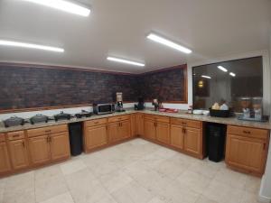 a large kitchen with wooden cabinets and a large window at Alien Residence Inn in Pecos
