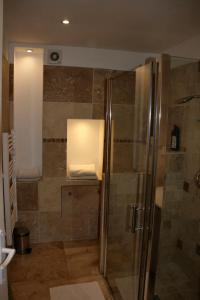 アヴィニョンにあるLa Fusterie 2 chambresのバスルーム(ガラスドア付きのシャワー付)