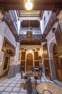uma sala vazia com mesas e cadeiras num edifício em Dar Meknes Tresor em Meknès