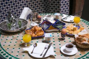 een tafel met een ontbijt van croissants en jus d'orange bij Dar Meknes Tresor in Meknès