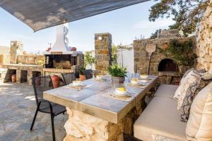 a table and chairs on a patio with a fireplace at Louros Spa House in Mármara