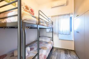 two bunk beds in a small room with a window at Louros Spa House in Mármara