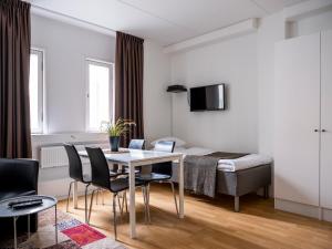 Cette chambre comprend une table, des chaises et un lit. dans l'établissement Slagsta Gate Hotell, à Norsborg