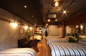 Zimmer mit 4 Betten, Tisch und Stühlen in der Unterkunft Guest House Re-worth Yabacho1 1F in Nagoya