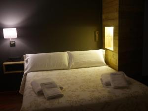a bedroom with a bed with two towels on it at Hotel Apartamentos Domenc in Aren