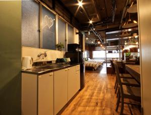 eine Küche mit einem Waschbecken und ein Wohnzimmer in der Unterkunft Guest House Re-worth Yabacho1 1F in Nagoya