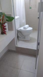 y baño con aseo blanco y ducha. en Departamentos de la Reina Roja en Palenque