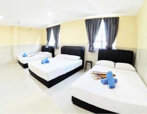 a bedroom with two beds and two blue chairs at Adamson Park Kuala Lumpur in Kuala Lumpur