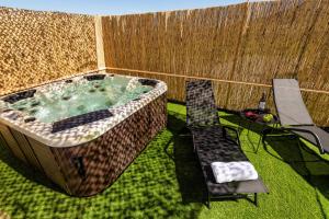 una bañera de hidromasaje en un patio trasero con un banco y una silla en Louros Spa House, en Mármara