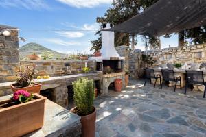 a patio with a fireplace and a table and chairs at Louros Spa House in Mármara
