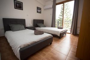 a bedroom with two beds and a large window at Serene Serenity in Paphos +63 photos