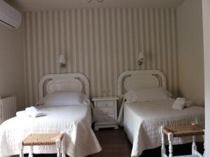 Hotel Domenc في Aren: غرفة فندقية بسريرين و كرسيين
