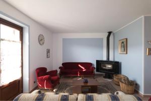a living room with a red couch and a fireplace at Villa con piscina e intera struttura a uso esclusivo casa del moré in La Morra