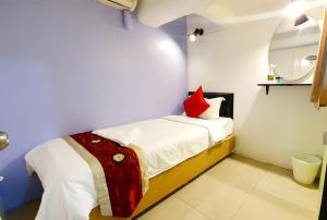 a small bedroom with a bed with a red pillow at Khaosan Art Hotel - SHA Plus Certified in Bangkok