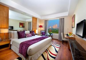 a hotel room with a large bed and a large window at The Place Gurugram, a member of Radisson Individuals in Gurgaon