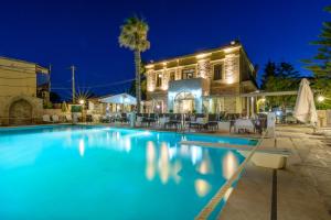 a swimming pool in front of a building at night at Grecian Castle Chios in Chios