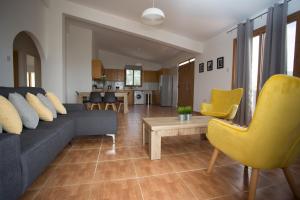 a living room with a blue couch and yellow chairs at Serene Serenity in Paphos