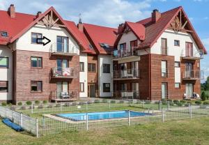 een appartementengebouw met een zwembad ervoor bij Widok in Jastrzębia Góra