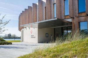 ein Gebäude mit Holzpaneelen an der Seite in der Unterkunft Domein Polderwind in Zuienkerke + 29 Fotos