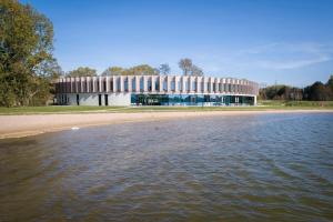 un edificio en la orilla de un cuerpo de agua en Domein Polderwind en Zuienkerke