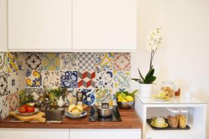 - une cuisine avec du carrelage coloré sur le mur dans l'établissement Residence Lì Galli, à Praiano