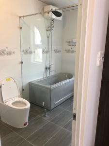 a bathroom with a bath tub and a toilet at Ngoc Lan Hotel and Coffee in Ðưc Trọng