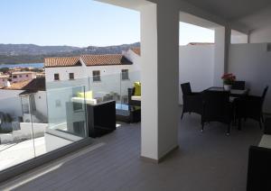 a view of a balcony with a table and chairs at NRH Cannigione Sunrise Rooftop in Cannigione