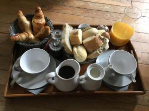 bandeja con tazas de café y bollería en una mesa en Gîte de la Tour Donjon, en Belcastel