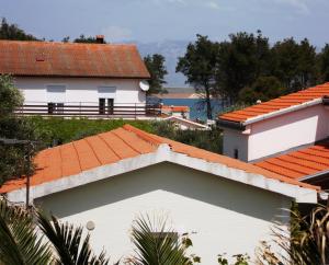 ein weißes Gebäude mit orangefarbenem Dach in der Unterkunft Apartman Čigir in Vir