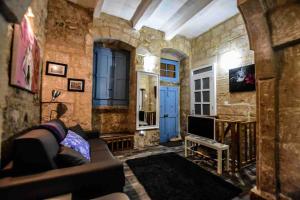 salon z kanapą i telewizorem w obiekcie Historic Townhouse in Birgu Center w mieście Vittoriosa