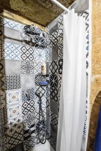 a bathroom with a black and white tiled wall at Historic Townhouse in Birgu Center in Vittoriosa +15 photos