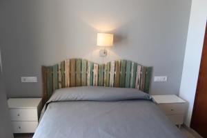 een slaapkamer met een bed met een hoofdeinde en een lamp bij Apartamentos Florida II in Peñíscola