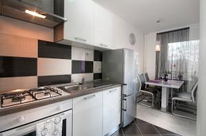 a kitchen with a stainless steel refrigerator and a table at Studio Blue Ivy in Plitvička Jezera