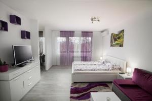 a white bedroom with a bed and a tv at Studio Blue Ivy in Plitvička Jezera
