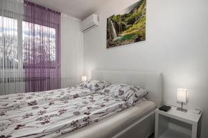 a white bedroom with a bed and a window at Studio Blue Ivy in Plitvička Jezera