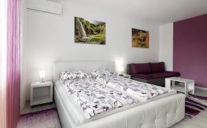 a bedroom with a white bed and a red chair at Studio Blue Ivy in Plitvička Jezera +13 photos