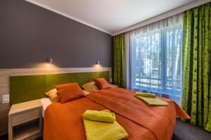 sypialnia z dużym łóżkiem i oknem w obiekcie Hotel *** NAT Krynica Morska w mieście Krynica Morska