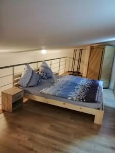 Bett mit blauer Bettwäsche und Kissen in einem Zimmer in der Unterkunft Ferienwohnung am Nürburgring/Wintersport Arft in Acht