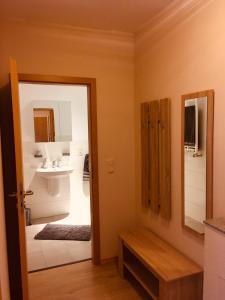 ein Badezimmer mit einem Waschbecken, einem Spiegel und einer Tür in der Unterkunft Ferienwohnung am Nürburgring/Wintersport Arft in Acht