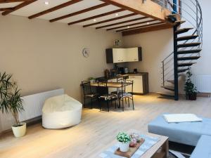 ein Wohnzimmer mit einem Sofa, einem Tisch und einer Treppe in der Unterkunft Ferienwohnung am Nürburgring/Wintersport Arft in Acht + 14 Fotos