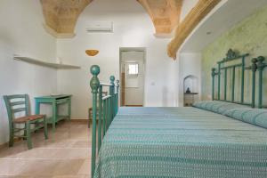 a bedroom with a green bed and a table at Villa Miliceddu in Tricase