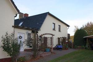 una casa blanca con una puerta y un patio en 2 Ferienwohnungen am Bodden (Nr.86), en Ralswiek