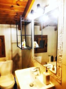 a bathroom with a sink and a toilet and a mirror at Romantic maisonette in the heart of Pythagoreio LH door in Pythagoreio