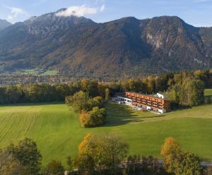 an aerial view of a house in a field with mountains at Klosterhof – Alpine Hideaway & Spa in Bad Reichenhall