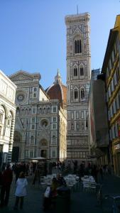 um grande edifício com uma torre de relógio em uma cidade em Accanto al Duomo em Florença