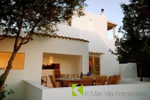 a white house with a table and chairs in front of it at K-Mari Villa Formentera in Playa Migjorn