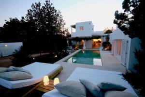 a swimming pool with two beds and a house at K-Mari Villa Formentera in Playa Migjorn