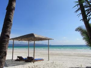 uma praia com duas cadeiras e um guarda-sol e o oceano em Sea Wind Resort em Boracay